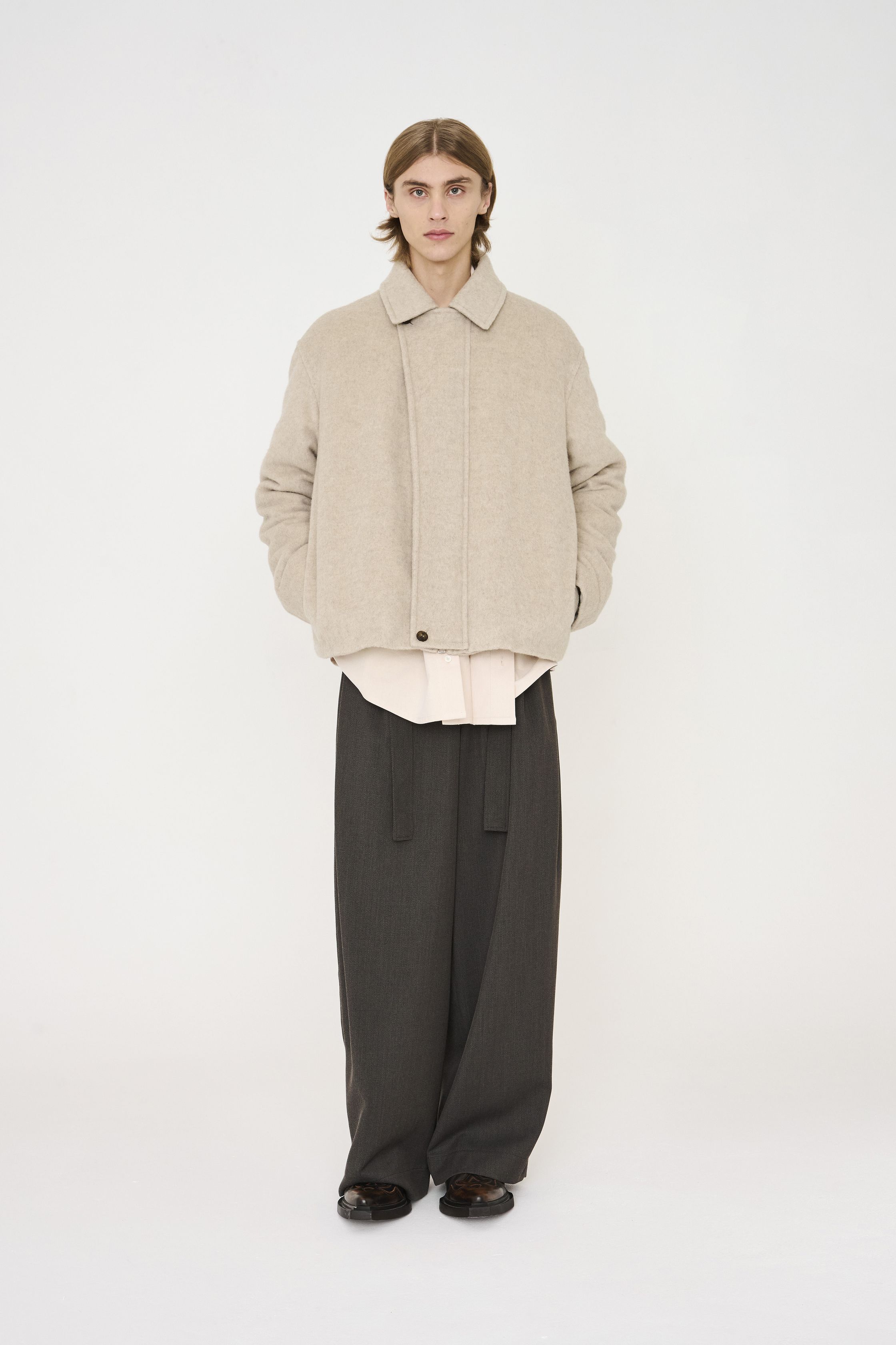 Nehera 26FW 延续品牌一贯的理性与克制，将中欧现代主义精神转化为高度可穿的当代衣橱。系列以灰、米、深蓝与低饱和卡其为主轴，宽松直线廓形与柔软面料并行，强调身体与服装之间的自然距离。外套、短夹克与宽裤通过层次与比例建立秩序感，设计不追求视觉刺激，而是通过结构稳定性与材质质感传达一种冷静、内省的力量。这是一种拒绝时尚喧哗的“安静理性”，非常契合当下全球对长期主义与真实穿着价值的回归-顽石频道趋势研究